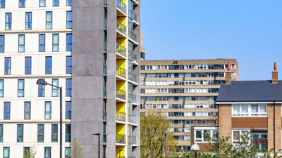 A modern apartment block in front of a social housing block