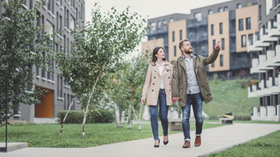 Two people walking down a pathway, one person is pointing