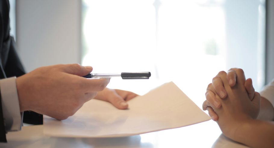 A property manager's hands handing documents to a second pair of hands