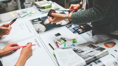 Image of the hands of people working on a magazine