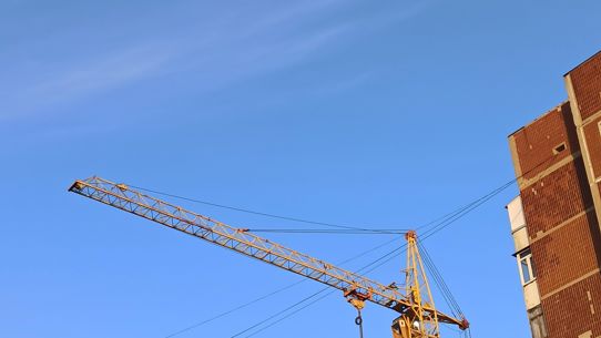 A crane over apartment blocks under construction during golden hour