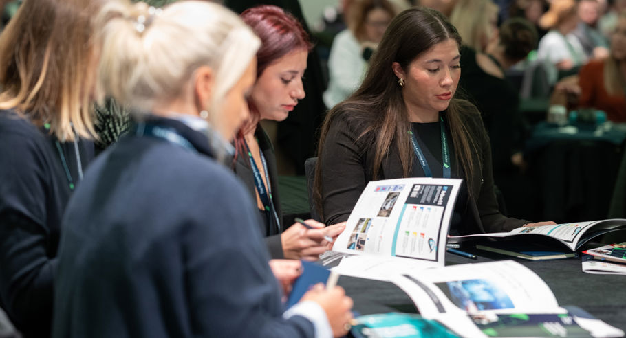 People Sitting around a table reading a brochure