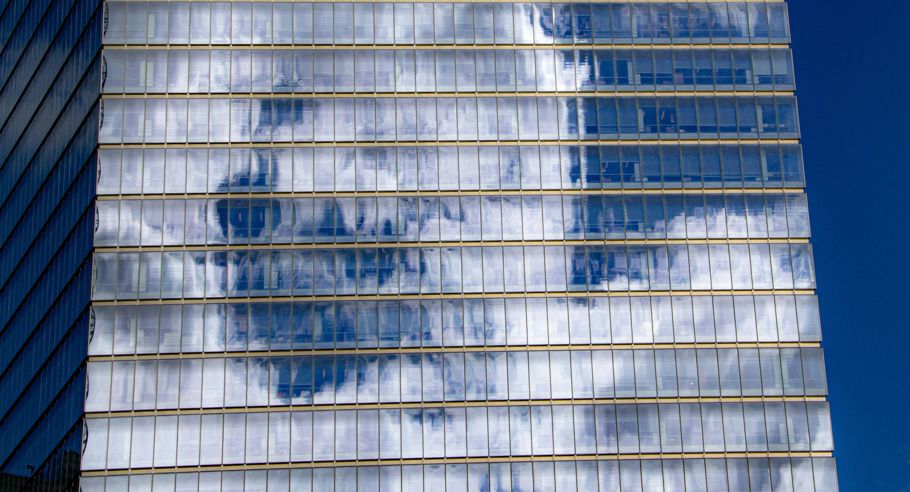 Clouds reflected off the glass of an office building