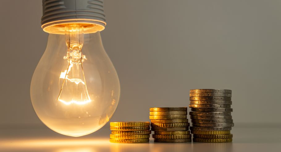 A lightbulb with coins next to it