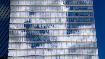 Clouds reflected off the glass of an office building