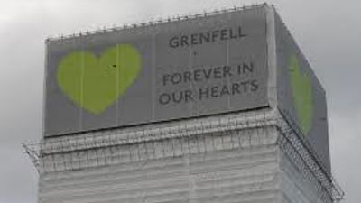 Grenfell tower with sign 'Grenfell, Forever in our hearts'