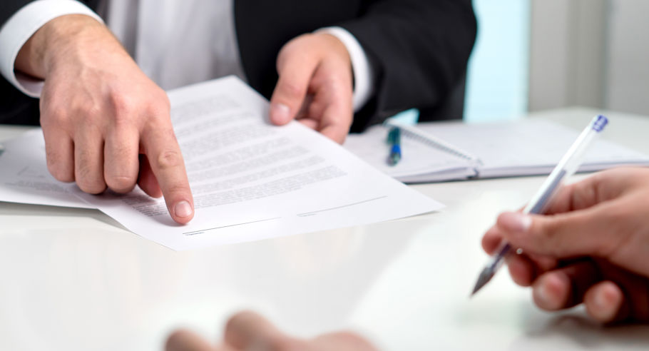 Close up of 2 people signing documents